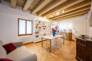 ヴェネツィアにあるParuta Corte Nascosta Apartmentのテーブルとキッチンのあるリビングルーム