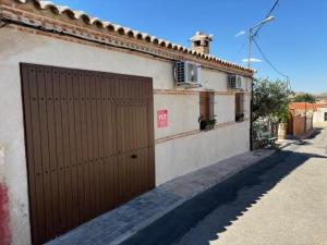 a building with a brown door on the side of it at Villa Mandrés. Casa con jardín y piscina. Proximo a Puy Du Fou. in Totanés