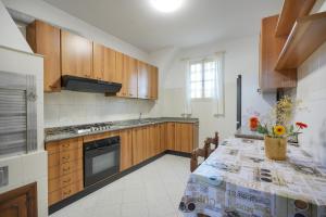 Una cocina con una mesa con un jarrón de flores encima. en Casale Mba Graziudd, en Monopoli