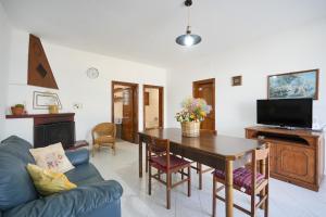 Una sala de estar con una mesa y un sofá azul. en Casale Mba Graziudd, en Monopoli