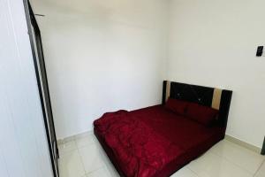 a bedroom with a red bed in a white wall at Homestay Sri Anggun Trio Setia Klang in Batu Unjor +3 photos