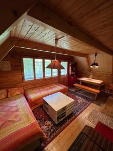 an attic living room with a couch and a table at Chata svätého Filipa in Hnilčík