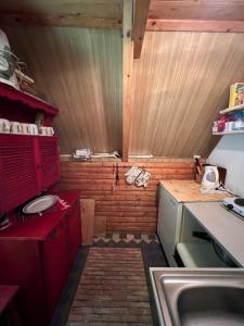 a small kitchen with red cabinets and a sink at Chata svätého Filipa in Hnilčík
