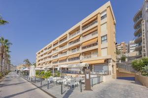 Un edificio con mesas y sillas delante. en Penélope, en Villajoyosa
