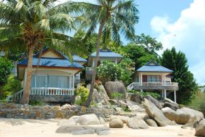 a house on the beach with palm trees at Phangan Sunset Resort in Ban Tai