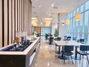 a restaurant with tables and chairs and windows at MD Hotel Doksan in Seoul