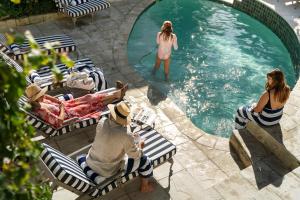 a group of people sitting in chairs in a swimming pool at Blackheath Lodge by The Oyster Collection in Cape Town
