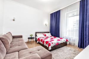 a living room with a couch and a bed at Apartments EXPO Residence in Taldykolʼ