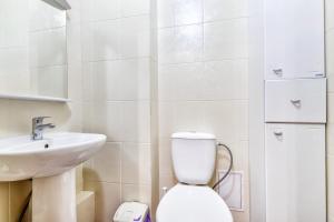 a white bathroom with a toilet and a sink at Apartments EXPO Residence in Taldykolʼ