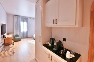 a kitchen with white cabinets and a counter top at KCOR Hotels in Ḩārat at Taḩtā