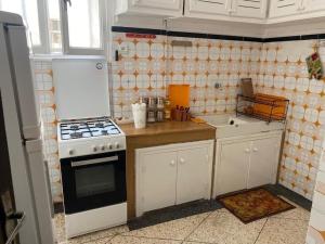 a kitchen with white cabinets and a stove top oven at Apartment Hamria Central in Meknès