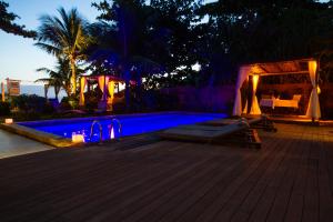 a swimming pool at a resort at night at Hotel Spa Nau Royal in Camburi