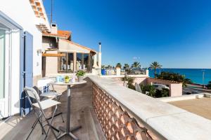 a balcony with a table and chairs and the ocean at La Maison Du Pêcheur in Cagnes-sur-Mer
