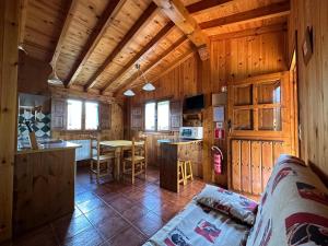 una cucina e un soggiorno in una baita di tronchi di Las Casucas a Villegar