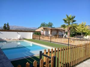 a house with a fence and a swimming pool at Atalaya de los Bermejales Villa privada piscina in Los Morales