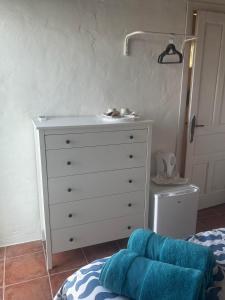 una camera da letto con una cassettiera bianca con un lavandino di HACIENDA LA MACARENA DE SEVILLA a Cantillana