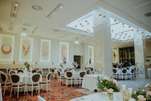 a banquet hall with white tables and chairs at Unirea Hotel & Spa in Iaşi +37 photos