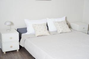 a white bedroom with a bed and a night stand at Su Casa - Rezerva acum apartament Spatios ultracentral, ceai, cafea, filtru apa rece-fierbinte, parcare gratuita in zona in Craiova