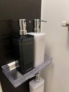 dos dispensadores de jabón sentados en un estante en un baño en 新井1丁目, en Tokio 46 fotos más