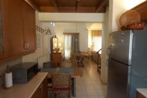 a kitchen with a refrigerator and a living room at Βίλα Στέλλα Ιωάννης in Agia Pelagia