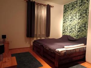 a bedroom with a bed and a window at Dézsa Apartman Balatonalmádi in Balatonalmádi
