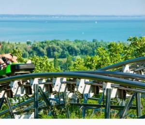 a group of people sitting at a table looking at the water at Dézsa Apartman Balatonalmádi in Balatonalmádi