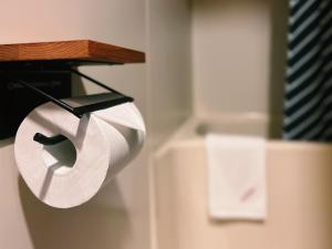 a roll of toilet paper is hanging on a holder at Hotel Wohnen in Hakuba