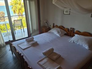 een slaapkamer met een groot bed met handdoeken erop bij Lefteris in Polichnítos