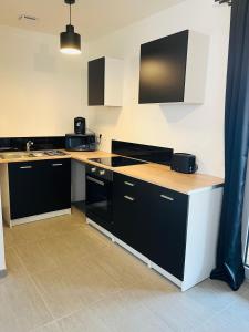 cocina con armarios en blanco y negro y encimera en Spa, en Marcheprime
