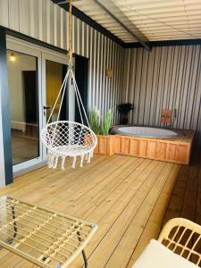 Un porche con una hamaca colgante en una terraza. en Spa, en Marcheprime 3 fotos más