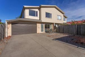 a house with a garage and a fence at Handy Riccarton Hagley Park CBD 10 Mins in Addington
