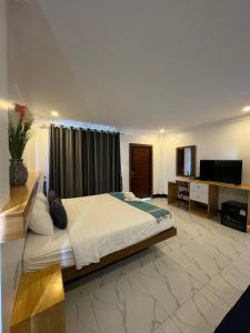 a bedroom with a large bed and a desk at SAMOT KHSACH RESORT ll in Kampot