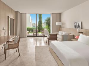 a hotel room with a bed and a living room at The Bodrum EDITION in Yalıkavak
