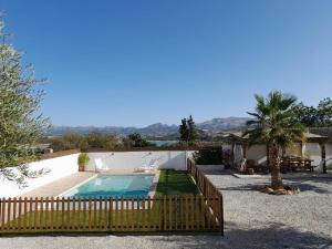 a villa with a swimming pool and a wooden fence at Atalaya de los Bermejales Villa privada piscina in Los Morales