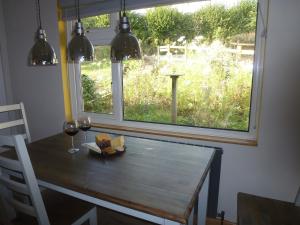 a dining room table with a view of a yard at Briardene Cottage - Devon countryside - sleeps 6 in Exeter