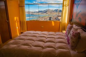 a large bed in a room with a large window at Wisny Inn in Puno