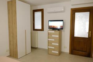 a room with a television and a dresser with a door at Casa Vacanze Il Confetto in Sulmona