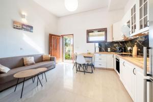 Una cocina y una sala de estar con un sofá y una mesa. en Melissa apartments, en Halikounas