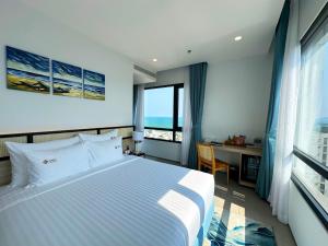 een slaapkamer met een bed, een bureau en een raam bij Odin Hotel Quy Nhon in Quy Nhon +102 foto's