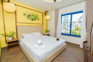 a bedroom with a large white bed with a window at Sujet Hotel Da Nang in Danang +54 photos