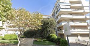 un alto edificio bianco con alberi di fronte di Bilocale con vista sull'aeroporto - comodo per il viaggio a Fiumicino
