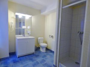 a bathroom with a sink and a toilet and a shower at Hotel du Centre in Pierrelatte