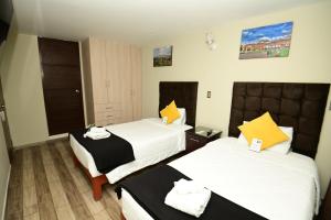 a hotel room with two beds with yellow pillows at Bon Repos Boutique in Arequipa +39 photos