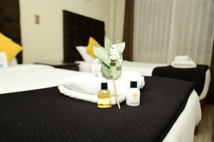 a hotel room with a bed with a black table with two bottles of oils at Bon Repos Boutique in Arequipa