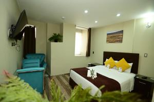 a hotel room with a bed and a blue chair at Bon Repos Boutique in Arequipa