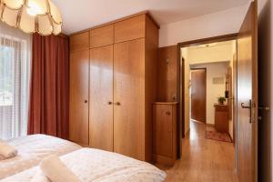 a bedroom with a bed and wooden cabinets at Apartment Kolmblick in Mayrhofen