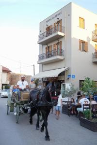 a horse drawn carriage on a street in front of a building at Porta Harenae Residencia in Chania