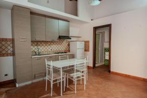 a kitchen with a table and chairs and a refrigerator at La discesa di San Giuseppe in Termini Imerese
