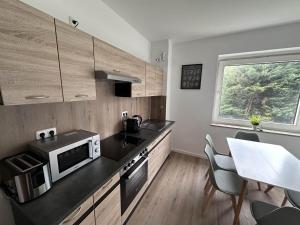una cucina con un bancone e un tavolo con sedie di Aparthotel 9 min to Dus Airport & 17 min to DUS Messe a Großenbaum
