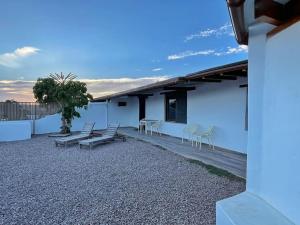 a patio with chairs and tables and a building at La Tierrua home in Tefía